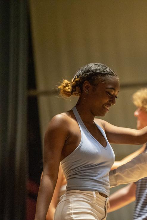 Students dance on stage for Greek Sing.