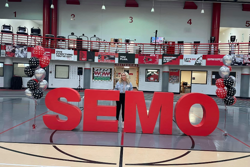 Alyssa standing in front the SEMO letters at an event