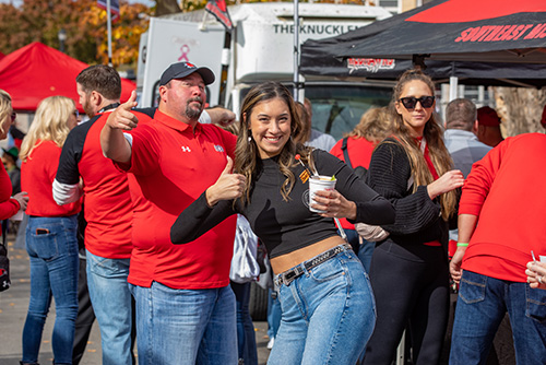 Two fans looking at the camera simling from their tent