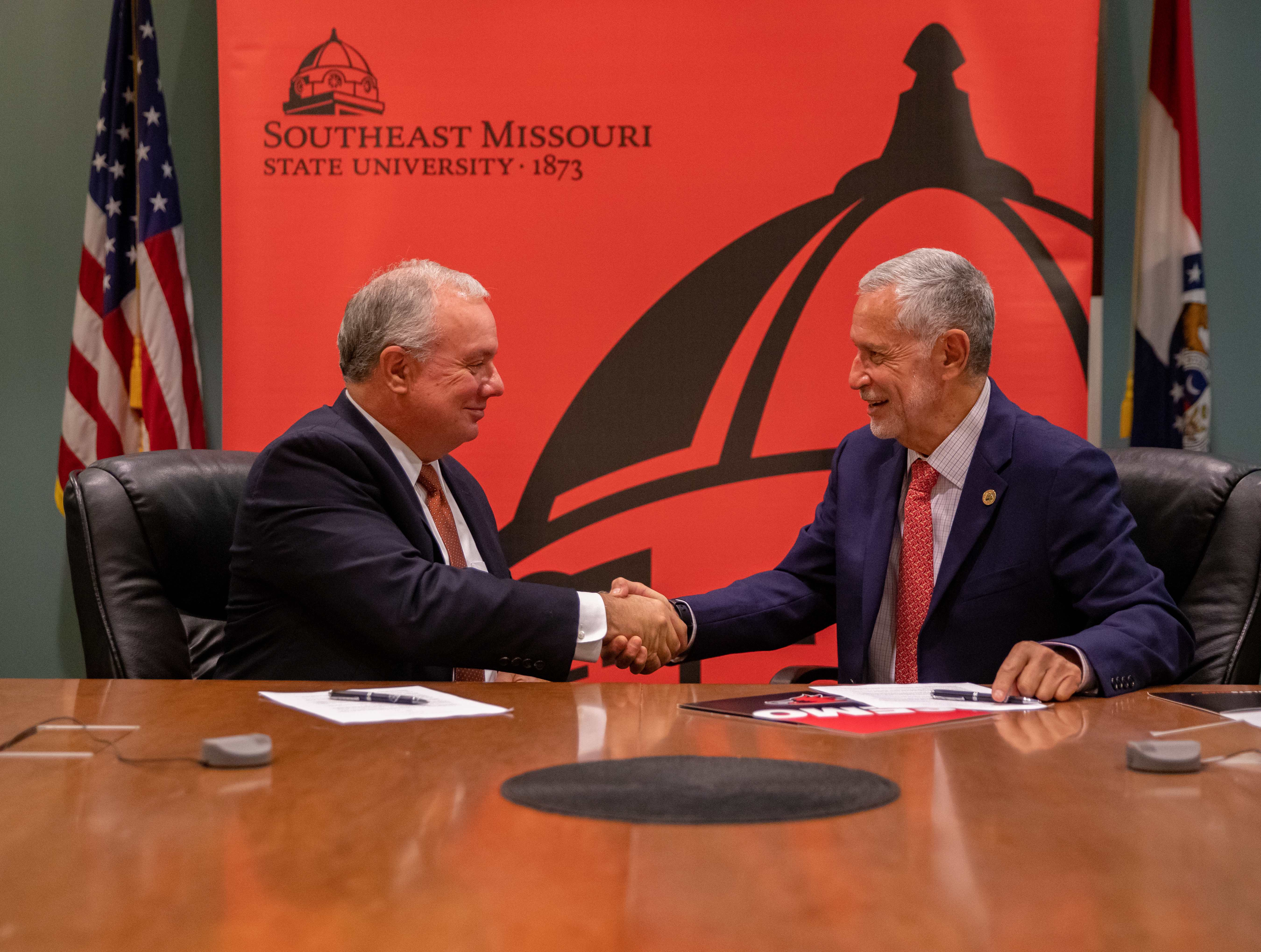 Dr. Vargas and Dr. Bauer shake hands after signing the memmorandum.