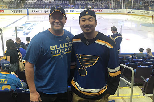 yuhei stands with a companion posing for a photo in his blue's jersy
