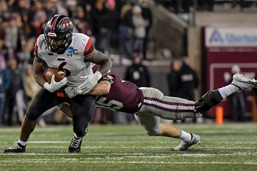 Geno Hess running the football in a white semo uniform