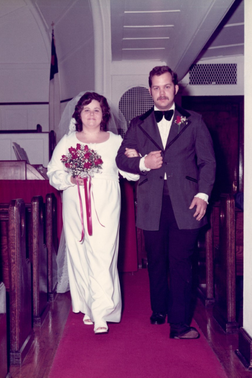 Ron and Jan walk together back down the aisle after their wedding.
