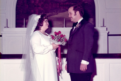 Ron and Jan stand facing each other in a church on their wedding day.