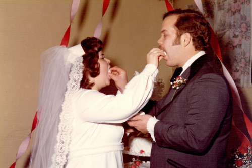 Ron and Jan feed each other cake at their wedding.