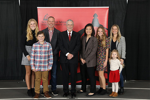 D.J. and Katie, along with their four kids, take a picture with University president Dr. Carlos Vargas and the inaugural scholarship recipient, Jennifer Tenholder