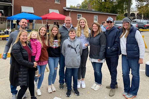 D.J., Katie and their four kids celebrate with friends at the 2021 tailgate they hosted to thank scholarship donors at Homecoming 2021