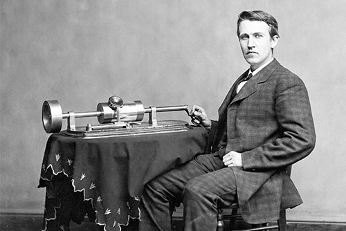 The inventor of the phonograph sits by the machine