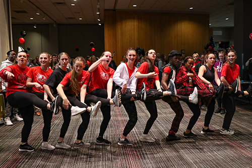 Dancers holding up one of their legs in a line dancing