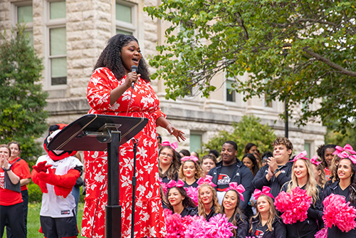 A woman stands on a stage and sings