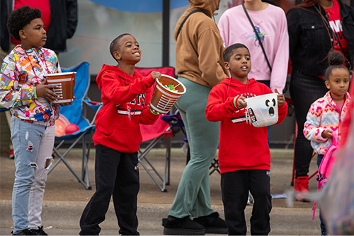 Kids hold containers and yell for candy