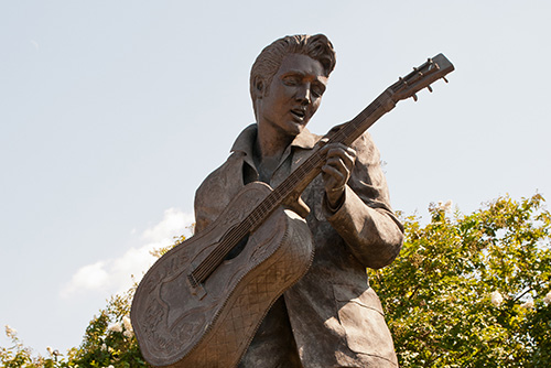 A status of Elvis Presley playing the guitar