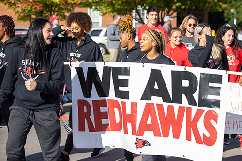 Students walk with a sign in a parade