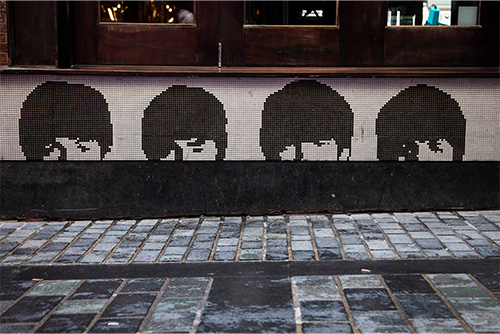 A sign shows the tops of the heads of the Beatles