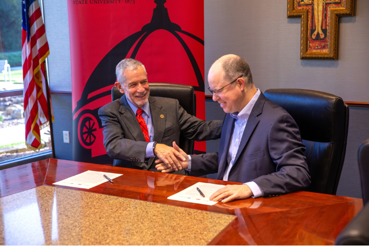 SEMO and Saint Francis leaders shake hands after signing agreement.