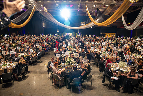 Everyone at the 150 Ball holding up their bid numbers.