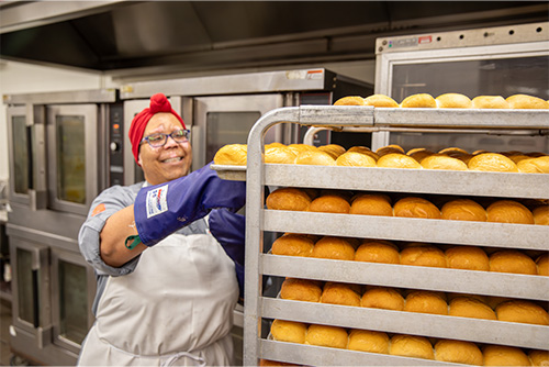 Chef from SEMO Dining putting the bread rolls on a tray.