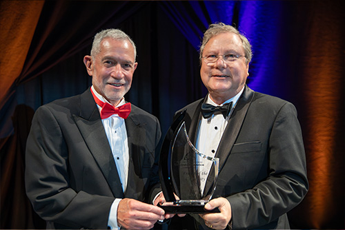 Friend of the University, David Blakemore, standing with his award and the President of the University
