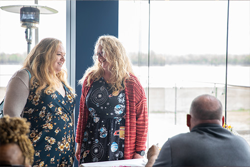 Foundation member talking to an alumni who has on a space dress for the eclipse
