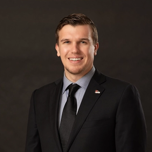 Professional headshot of Jordan Redd against a dark background.