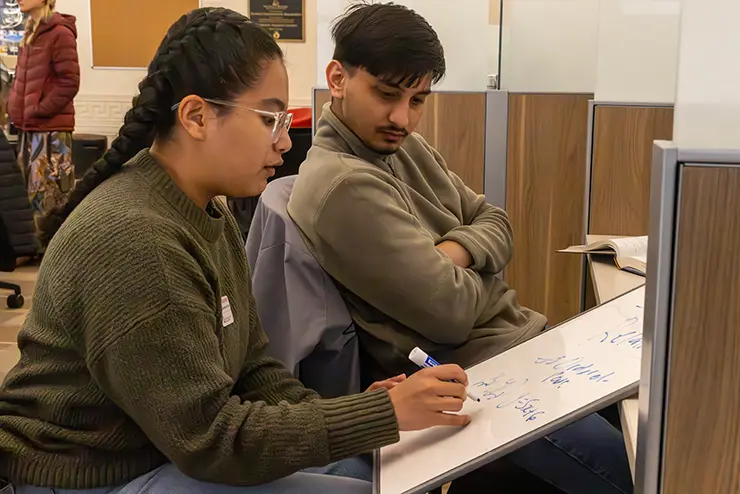 a math tutor sits with a SEMO student as they work through a math equation