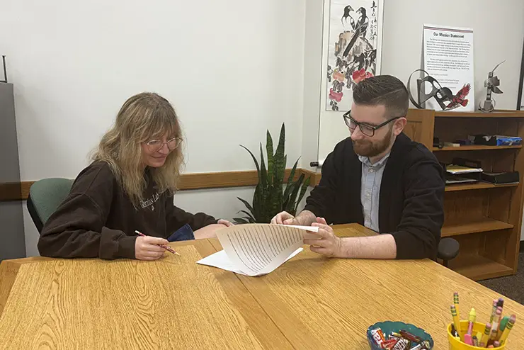 a writing lab tutor assists a student with a writing project