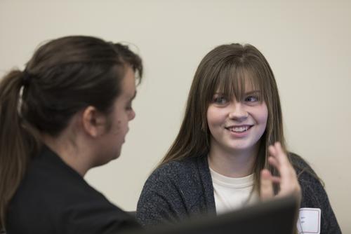 A student smiles while meeting a staff member for advisement.