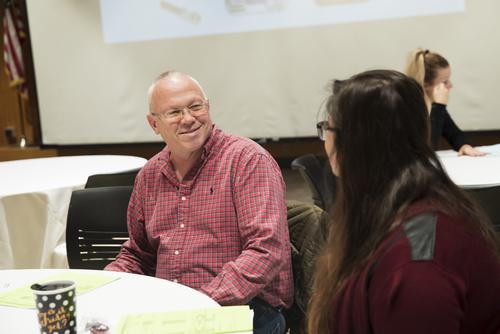 A faculty member smiles while meeting with a student at a First Step event.