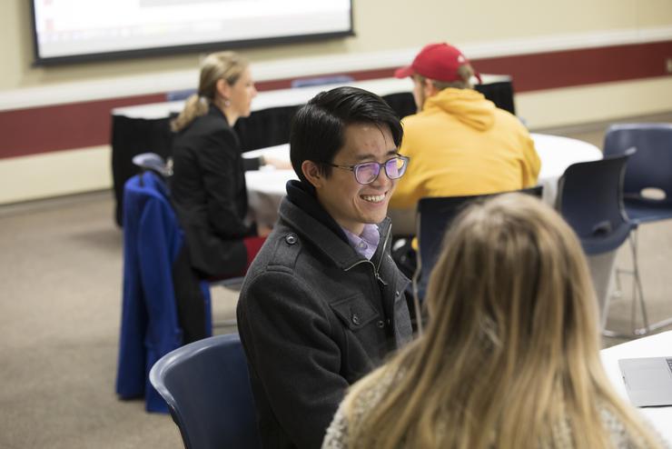 A student smiles while meeting with a faculty member at a First Step event.