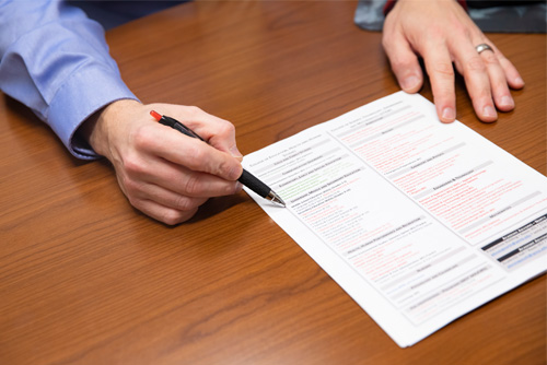 An academic advisor uses a pen to point out sections on a document.