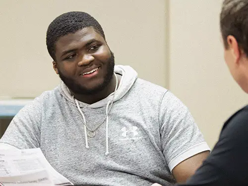 a SEMO student holds a degree map paper while he talks with an advisor