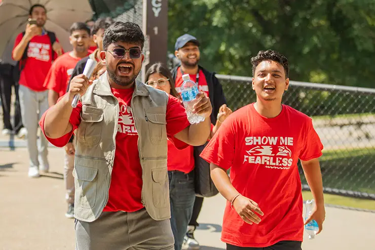 two new SEMO students cheer as they cross the walkway to Convocation