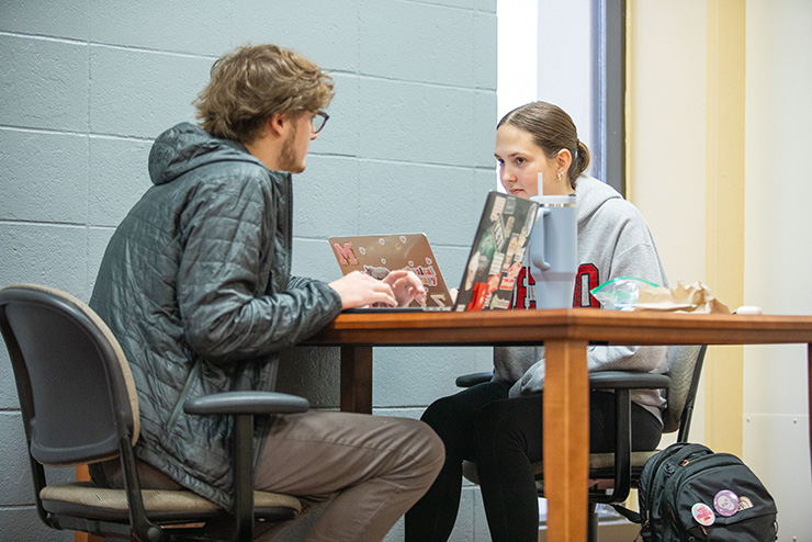 A SEMO student gets help in the library from another SEMO student.