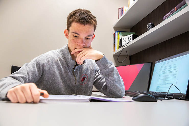 Southeast Missouri State University student studying alone at a desk preparing for exams.