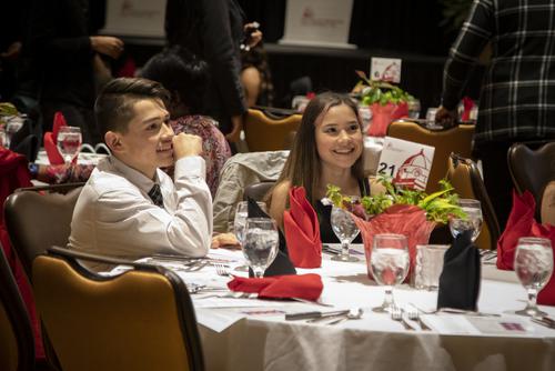 Students smile while sitting at a table during a TRIO Anniversary Banquet.