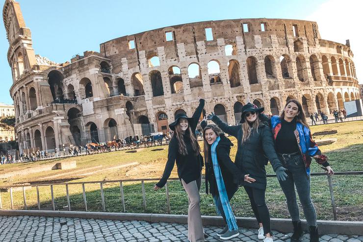 Students strike a pose in front of the Colosseum in Rome, Italy.