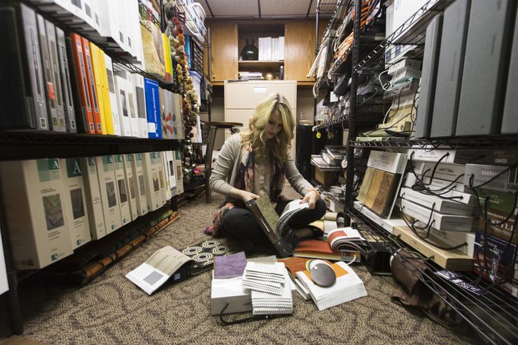 A student looks at textile samples during an interior design internship.