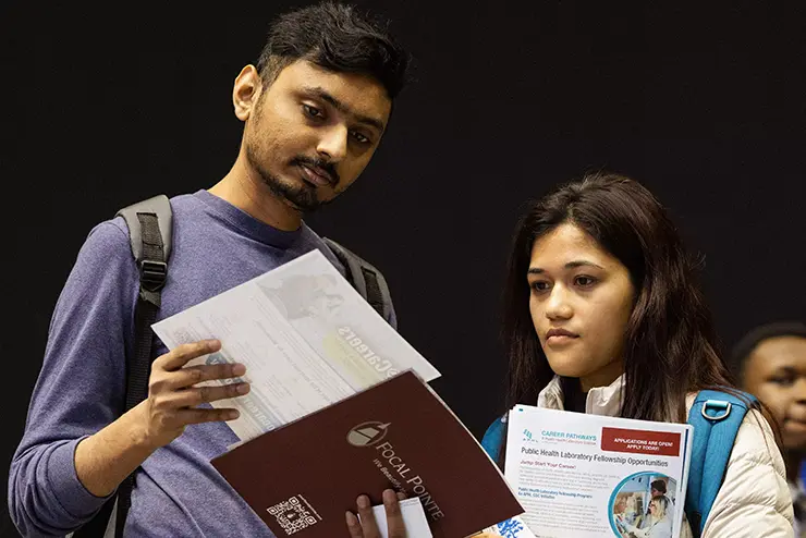 two students compare resumes at the career expo