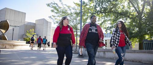 Three SEMO students smile as they walk together on campus.
