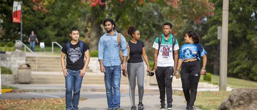 A group of International students at Southeast walk together on the sidewalk.