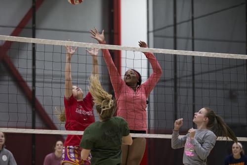 Students jump for a ball at the net while playing intramural volleyball in the Recreation Center.
