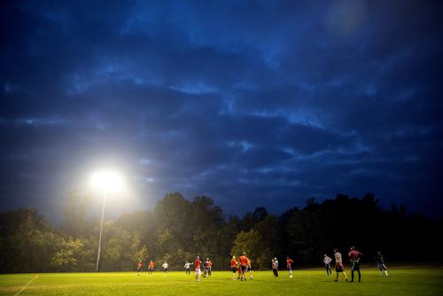 Illuminated by overhead lights, SEMO students play flag football after dark on Bertling Field. 