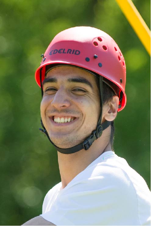 A student smiles as he takes on the Low Challenger ropes course.