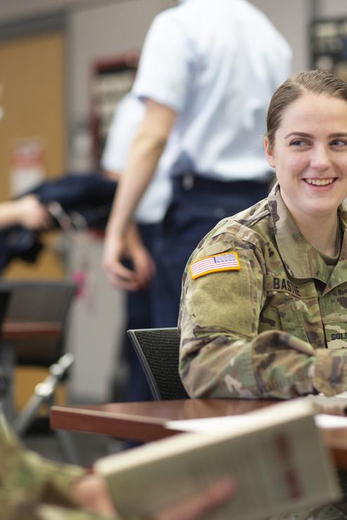A Show-Me Gold student smiles while sitting with peers at a table.