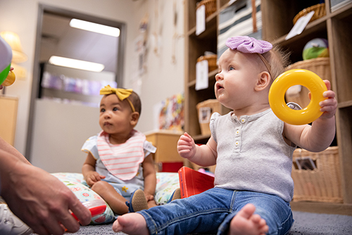  Children at the USYC sit as they listen to their teacher read them a story. 