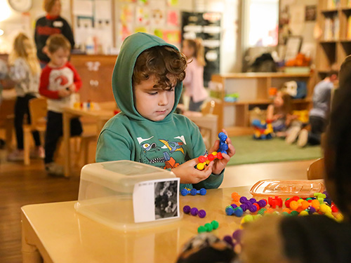 A kid plays with blocks at the USYC.