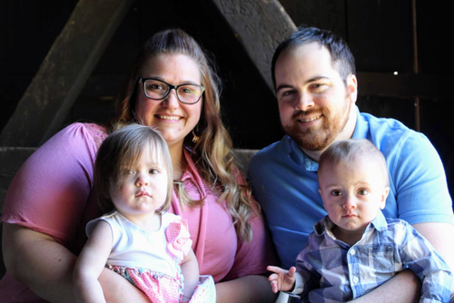 The Starr Family, a mother, father, and twin boy and girl, smile at the camera.