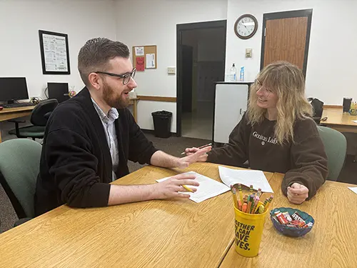 Student working with teacher on a paper 